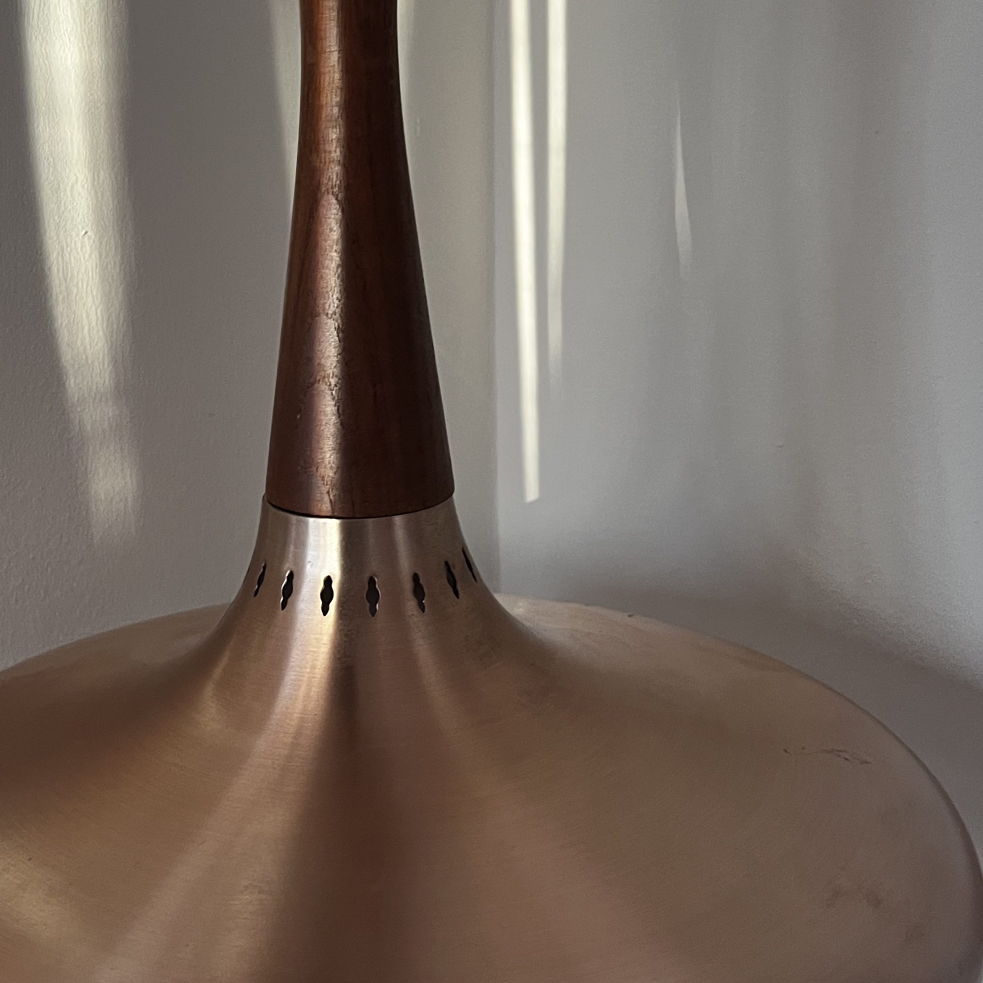 Close-up detail of the decorative top perforations on the copper-toned shade